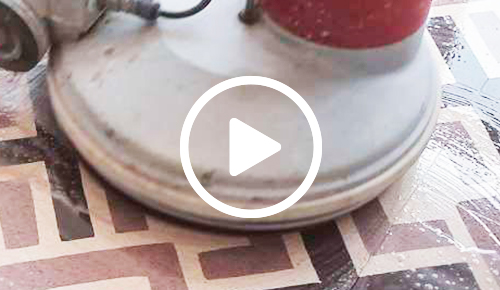 Reinigen Sie einen Granito-Fliesenboden mit einer Poliermaschine und einer Faserscheibe